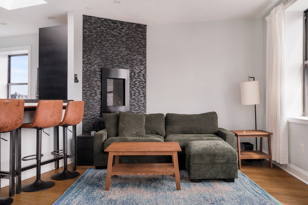 188 North Street, Unit 64 Boston, MA 02113 - Photo 20 of 27 a living room with furniture a wooden floor and a fireplace