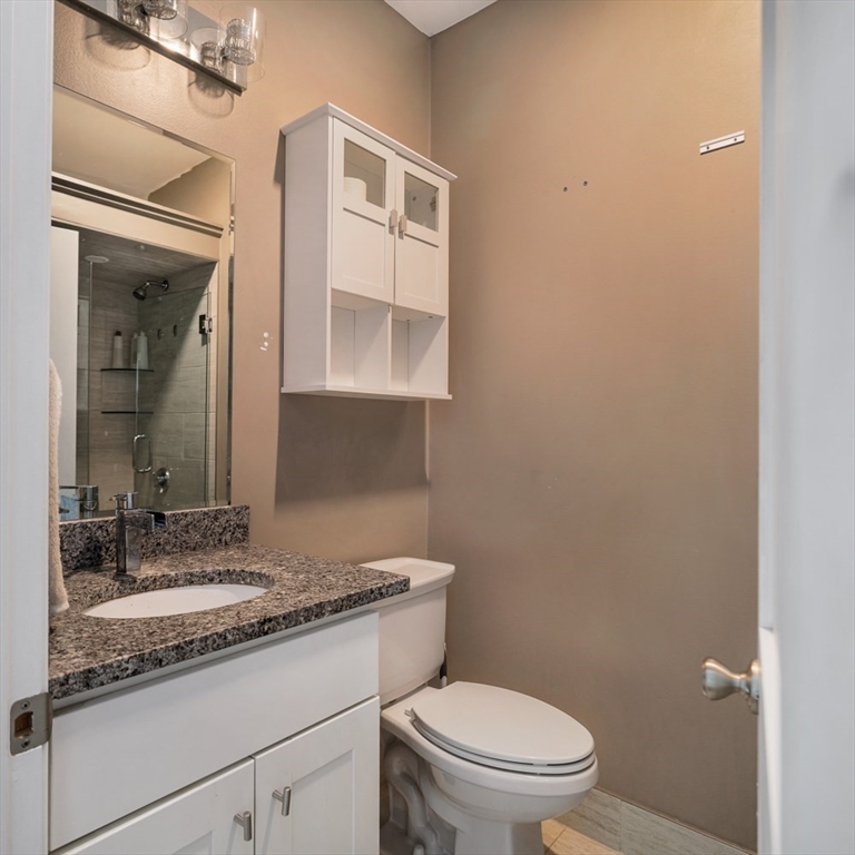188 North Street, Unit 64 Boston, MA 02113 - Photo 6 of 27 a bathroom with a granite countertop sink toilet and mirror