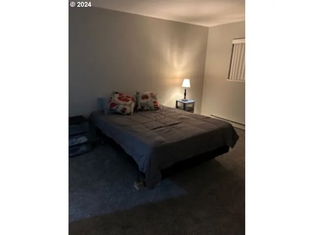 a bed sitting in a bedroom next to a bathroom with a sink