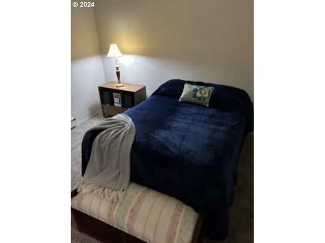 a bedroom with a bed and a lamp
