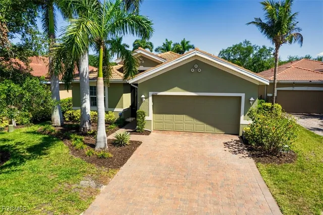 a front view of a house with a yard and potted plants