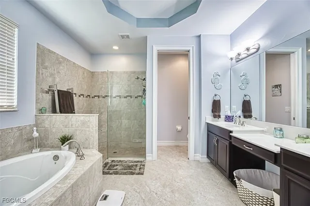 a spacious bathroom with a tub sink toilet and mirror