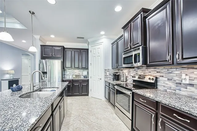a kitchen with stainless steel appliances granite countertop a sink refrigerator and microwave