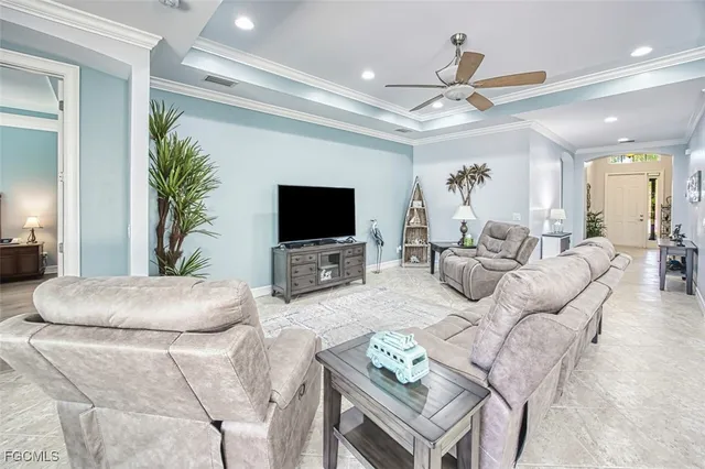 a living room with furniture a flat screen tv and a chandelier