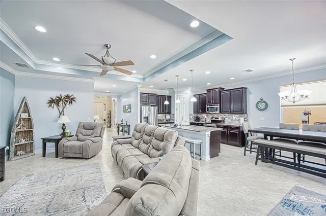 a living room with furniture kitchen view and a wooden floor