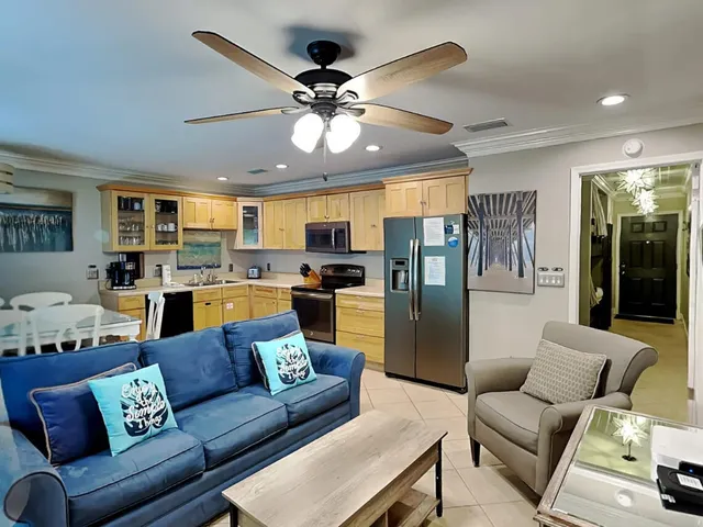 a living room with furniture kitchen view and a chandelier