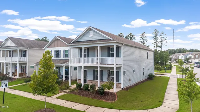 a view of a white house with large windows and a table and chairs