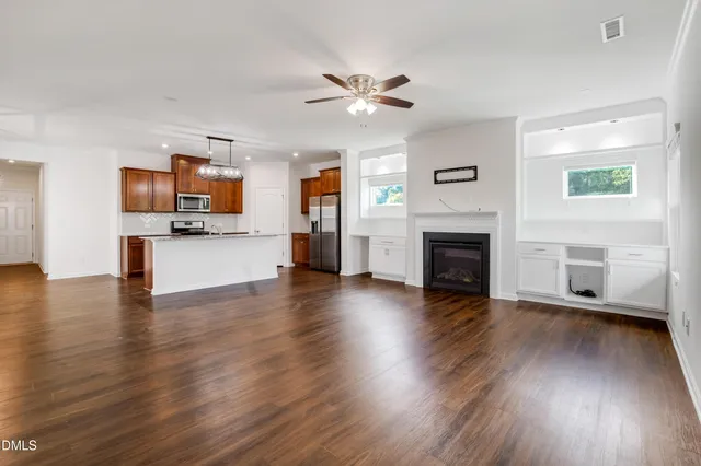 a view of a kitchen with wooden floor and a kitchen space with a sink
