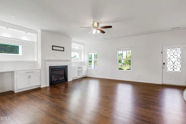 wooden floor fireplace and windows in an empty room