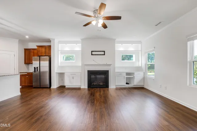 a kitchen with stainless steel appliances granite countertop a refrigerator a oven a stove and a wooden floors