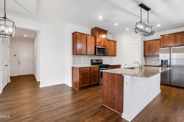 a kitchen with stainless steel appliances granite countertop wooden floors a sink and a stove