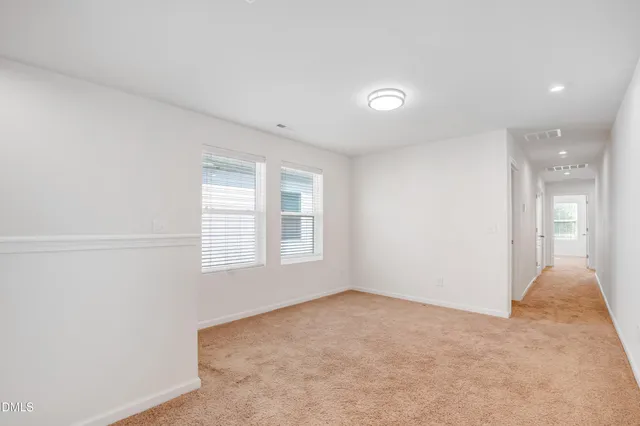 an empty room with a ceiling fan and bathroom space