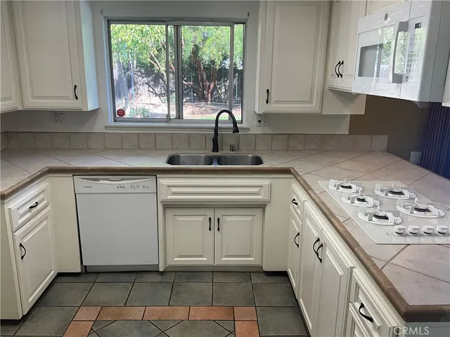 a kitchen with white cabinets and white appliances