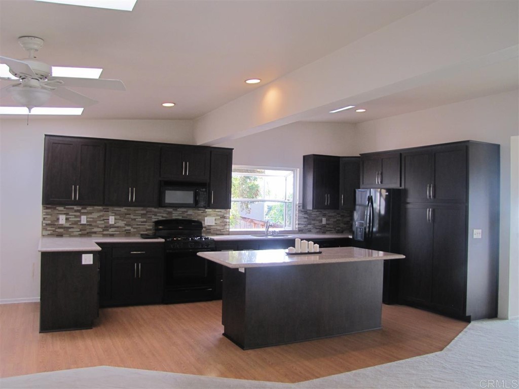 714 Barbara Avenue Solana Beach, CA 92075 - Photo 6 of 7 a kitchen with stainless steel appliances granite countertop a sink stove and refrigerator