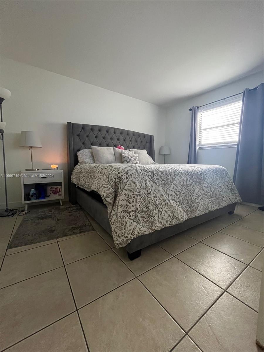 8075 Northwest 7th Street, Unit 109 Miami, FL 33126 - Photo 11 of 14 a spacious bedroom with a bed and a window in it