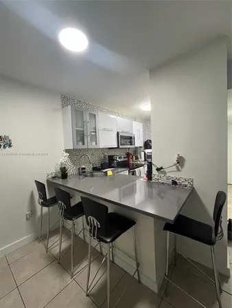 a kitchen with a dining table chairs and white cabinets