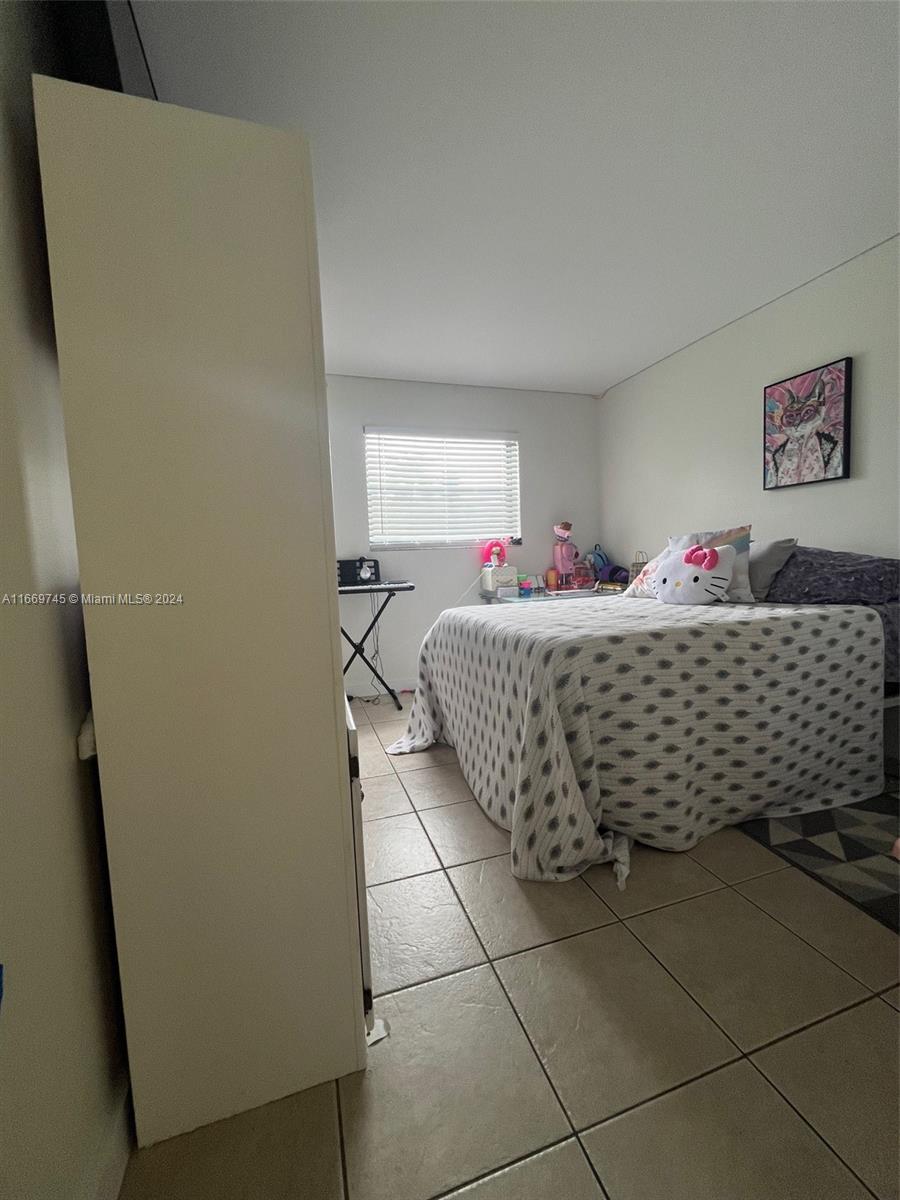 8075 Northwest 7th Street, Unit 109 Miami, FL 33126 - Photo 10 of 14 a room with bed and window