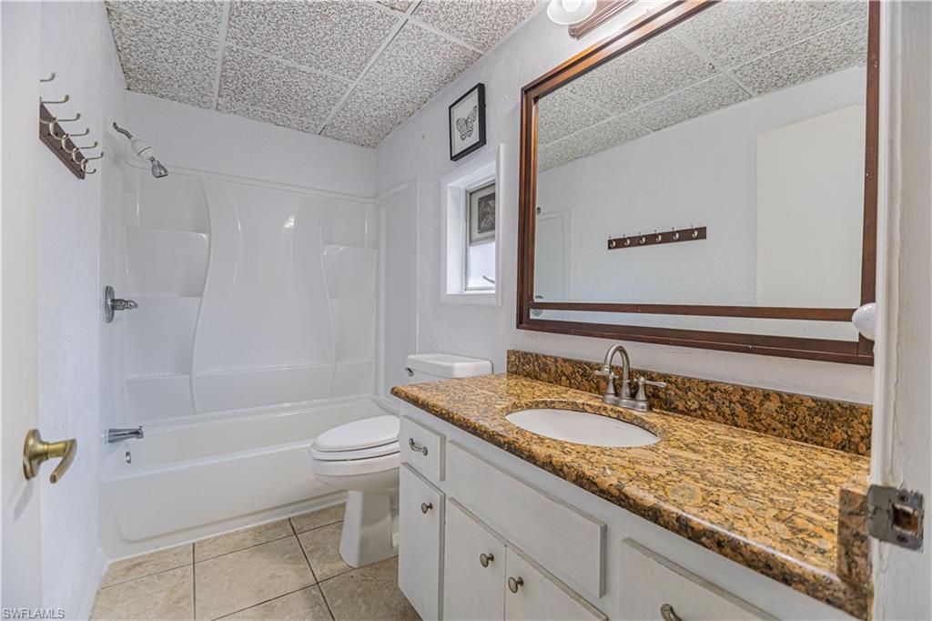 1003 Trail Terrace Drive Naples, FL 34103 - Photo 12 of 23 a bathroom with a granite countertop sink a toilet and bathtub