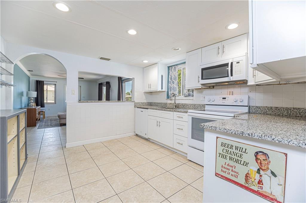 1003 Trail Terrace Drive Naples, FL 34103 - Photo 13 of 23 a kitchen with stainless steel appliances granite countertop a refrigerator and a stove top oven
