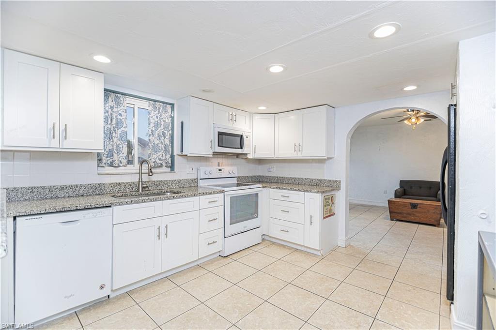 1003 Trail Terrace Drive Naples, FL 34103 - Photo 14 of 23 a kitchen with granite countertop white cabinets and white appliances
