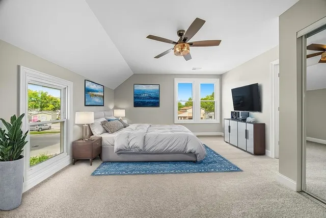 a spacious bedroom with a large bed and a flat screen tv