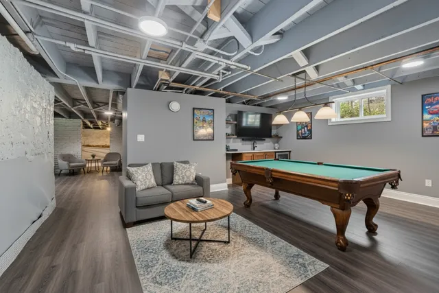 a reading room with furniture pool table and a rug