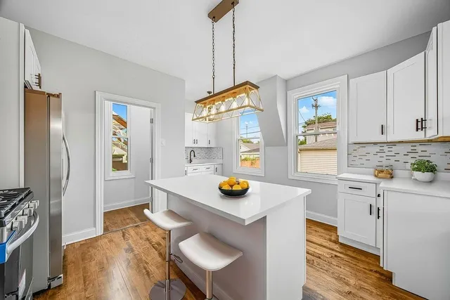 a kitchen with stainless steel appliances a stove a sink cabinets and a dining table