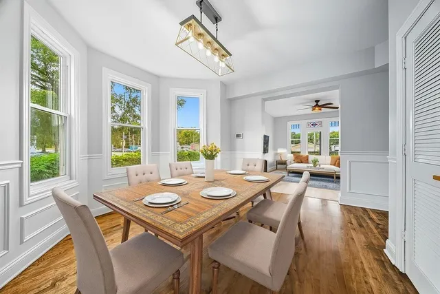 a view of a dining room and livingroom with furniture wooden floor and a rug
