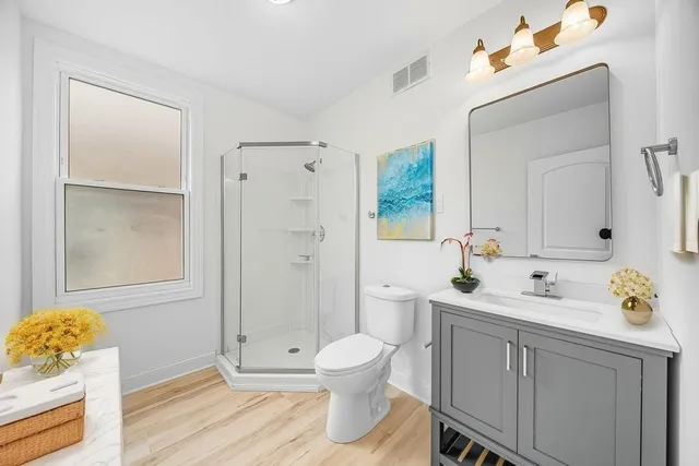 a bathroom with a sink a toilet and shower