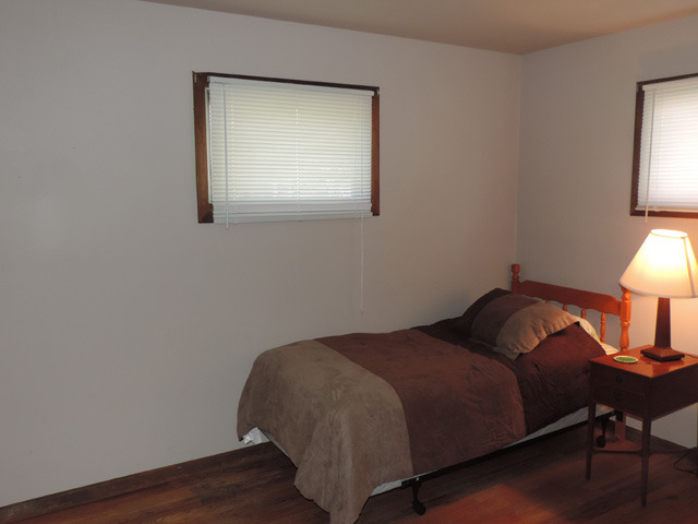 106 Thornton Street Lockport, IL 60441 - Photo 7 of 9 a bed sitting in a bedroom next to a lamp