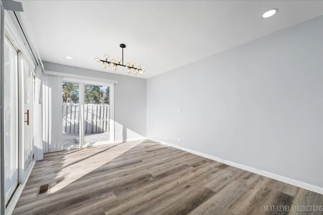 a view of a livingroom with wooden floor and a hallway
