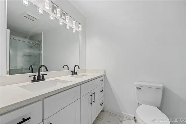 a bathroom with a toilet a sink and mirror