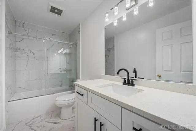 a bathroom with a sink toilet a mirror and shower