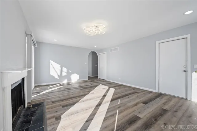 a view of an empty room with a fireplace and a window