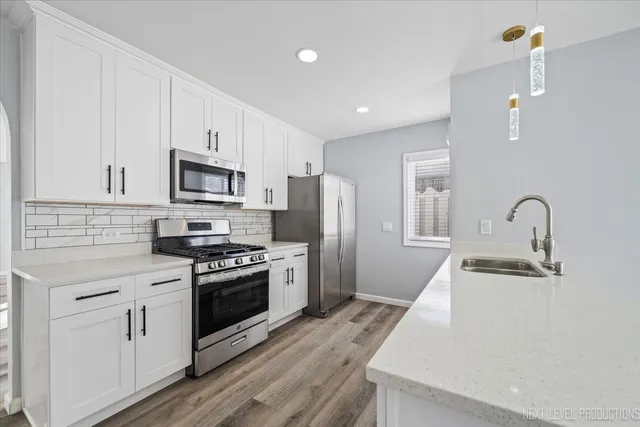 a kitchen with white cabinets and stainless steel appliances