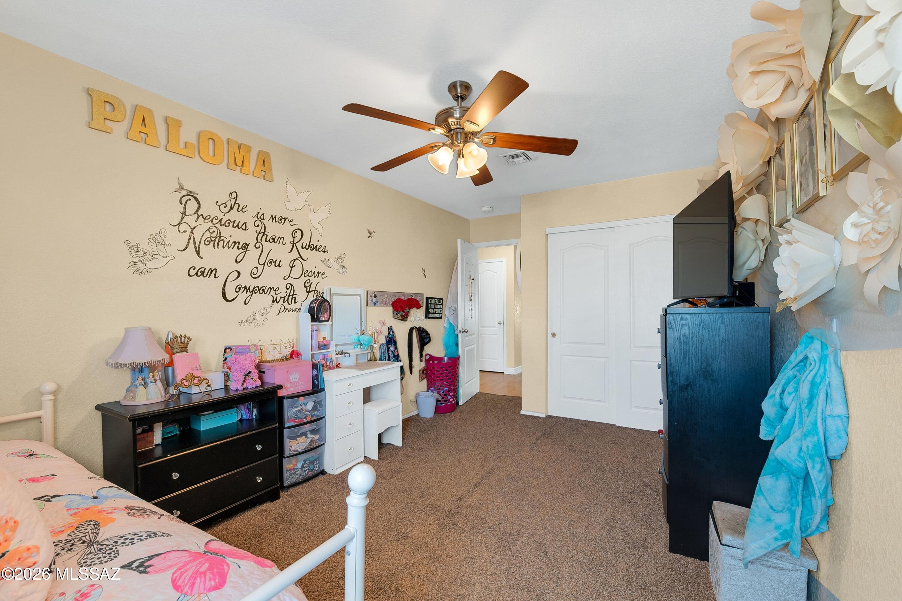 7159 West Maple Ridge Drive Tucson, AZ 85743 - Photo 19 of 42 a bedroom with a bed and a chandelier