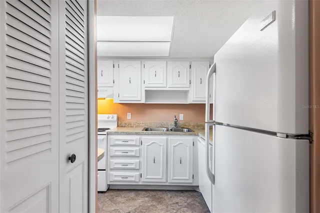 a kitchen with granite countertop white cabinets and sink