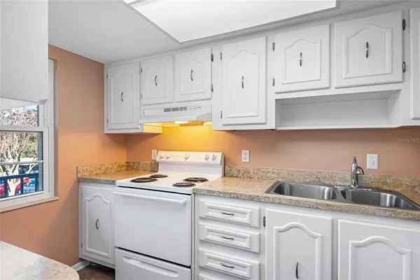 a kitchen with cabinets appliances a sink and a counter top