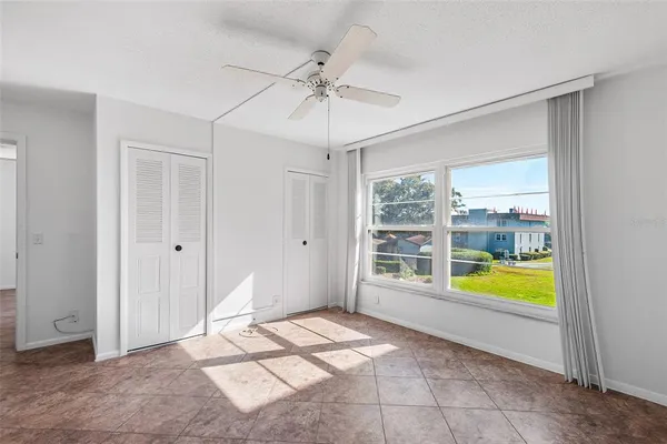 a view of a bedroom with cabinet and chandelier fan