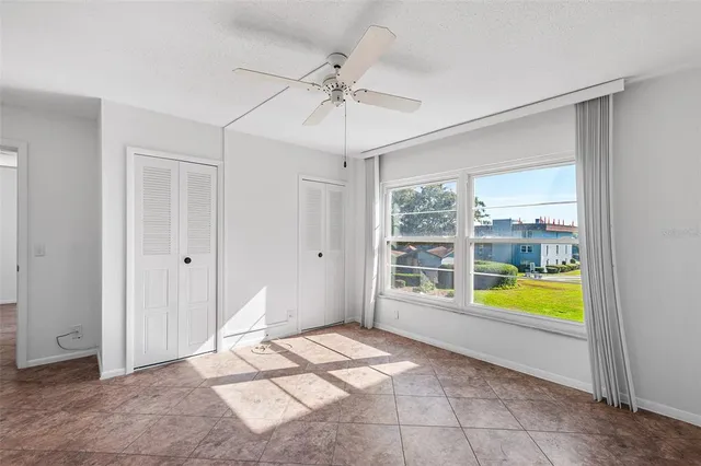 a view of a bedroom with cabinet and chandelier fan