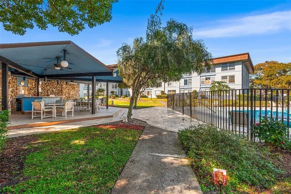 a patio with table and chairs and potted plants