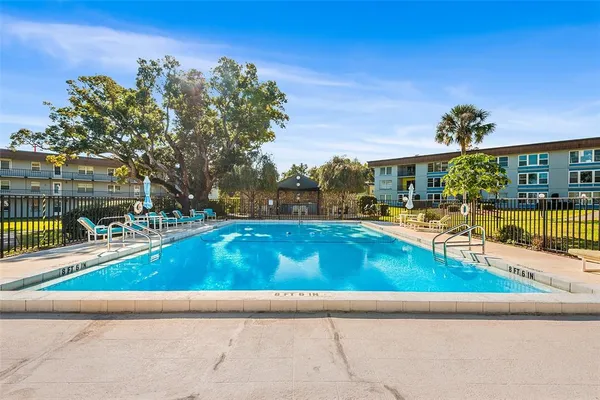a view of a swimming pool with a garden and trees