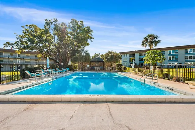 a view of a swimming pool with a garden and trees