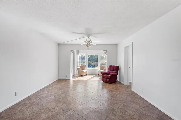 an empty room with furniture and a large window
