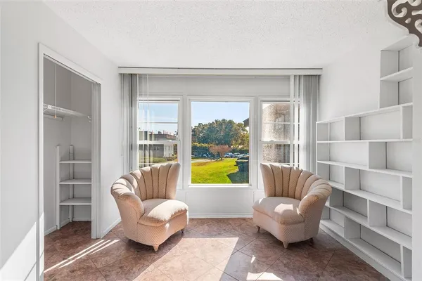 a kitchen with granite countertop a refrigerator a sink a stove and white cabinets