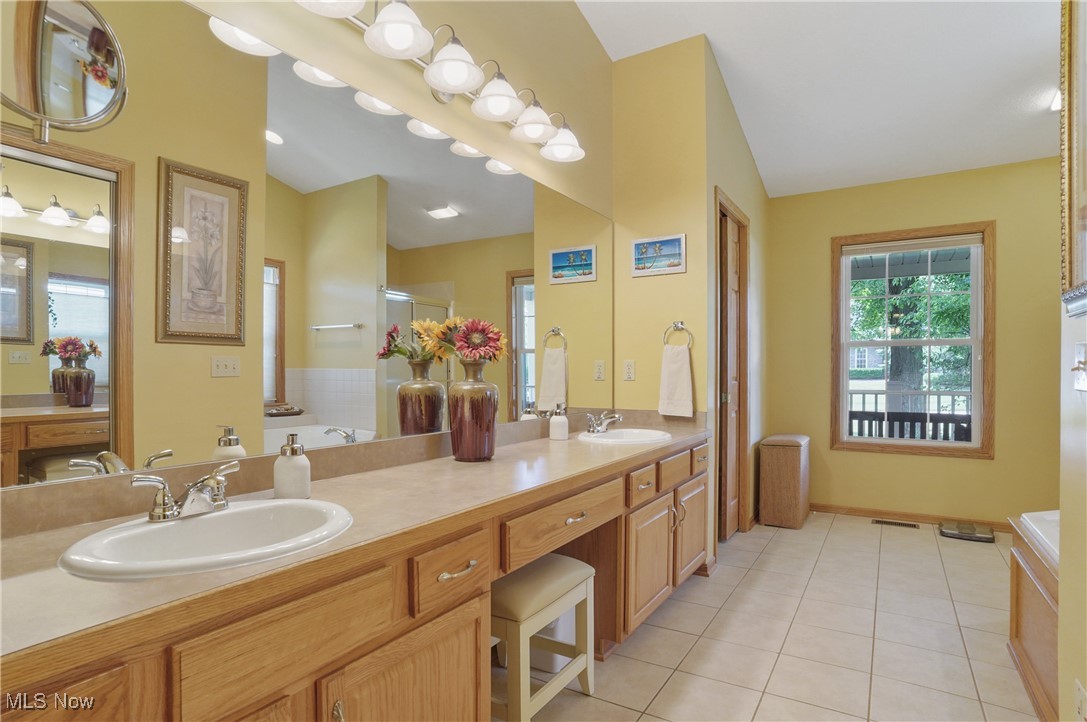 4265 Ridge Crest Drive Akron, OH 44321 - Photo 24 of 49 Bathroom with vaulted ceiling, double vanity, tile patterned floors, a tub to relax in, and a shower