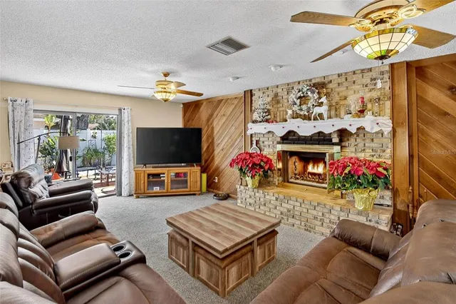 a living room with furniture a flat screen tv and a floor to ceiling window