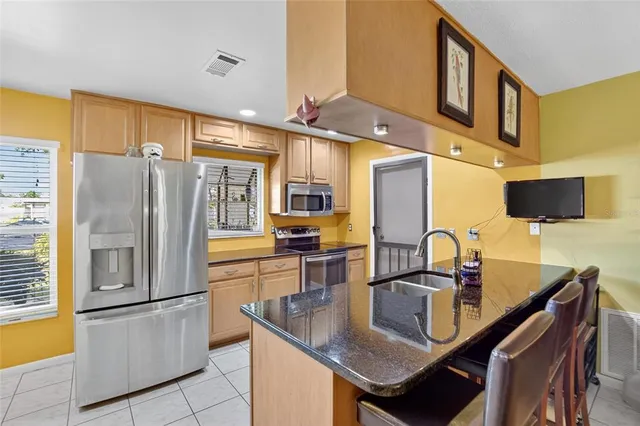 a kitchen with stainless steel appliances granite countertop a sink refrigerator and cabinets