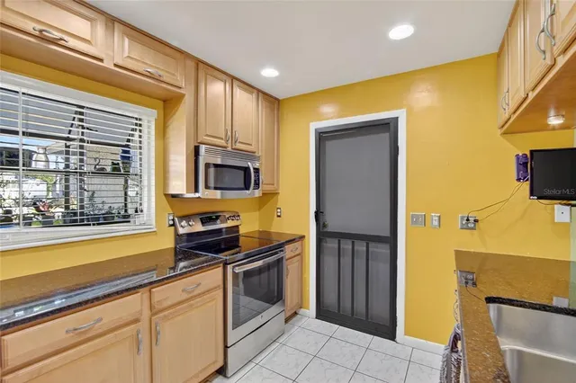 a kitchen with stainless steel appliances granite countertop a stove a sink and a refrigerator