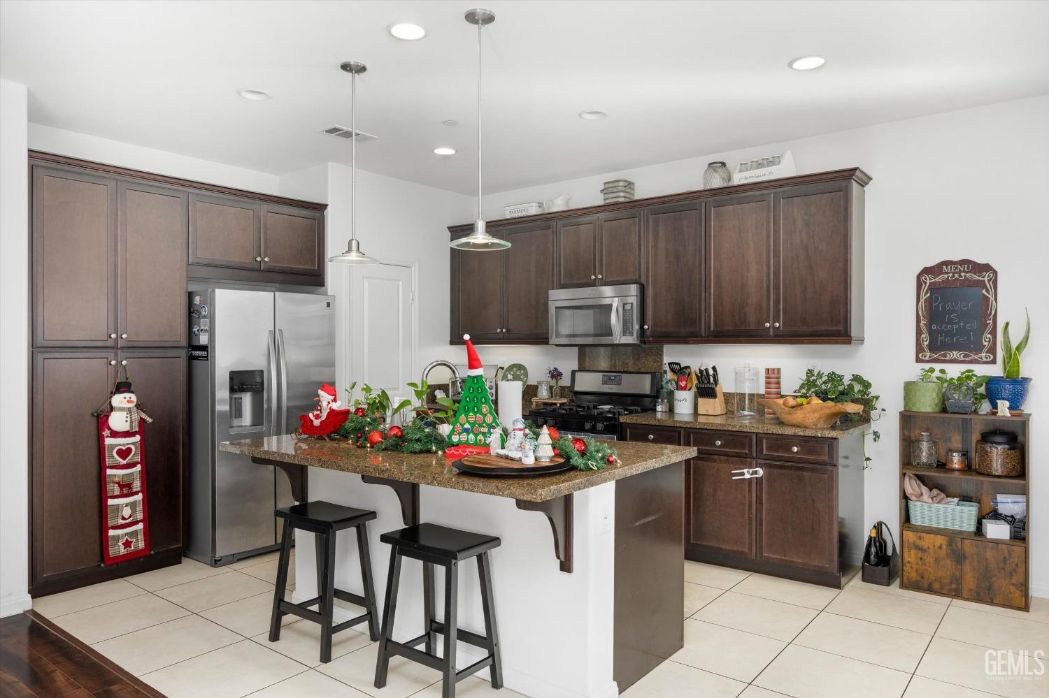 Undisclosed Address Bakersfield, CA 93313 - Photo 13 of 27 a kitchen with kitchen island granite countertop a stove cabinets and a refrigerator